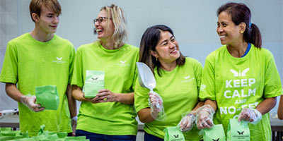 Volunteers smiling and laughing sorting paper bags