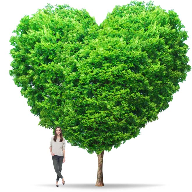 Smiling woman standing next to a tree shaped like a heart