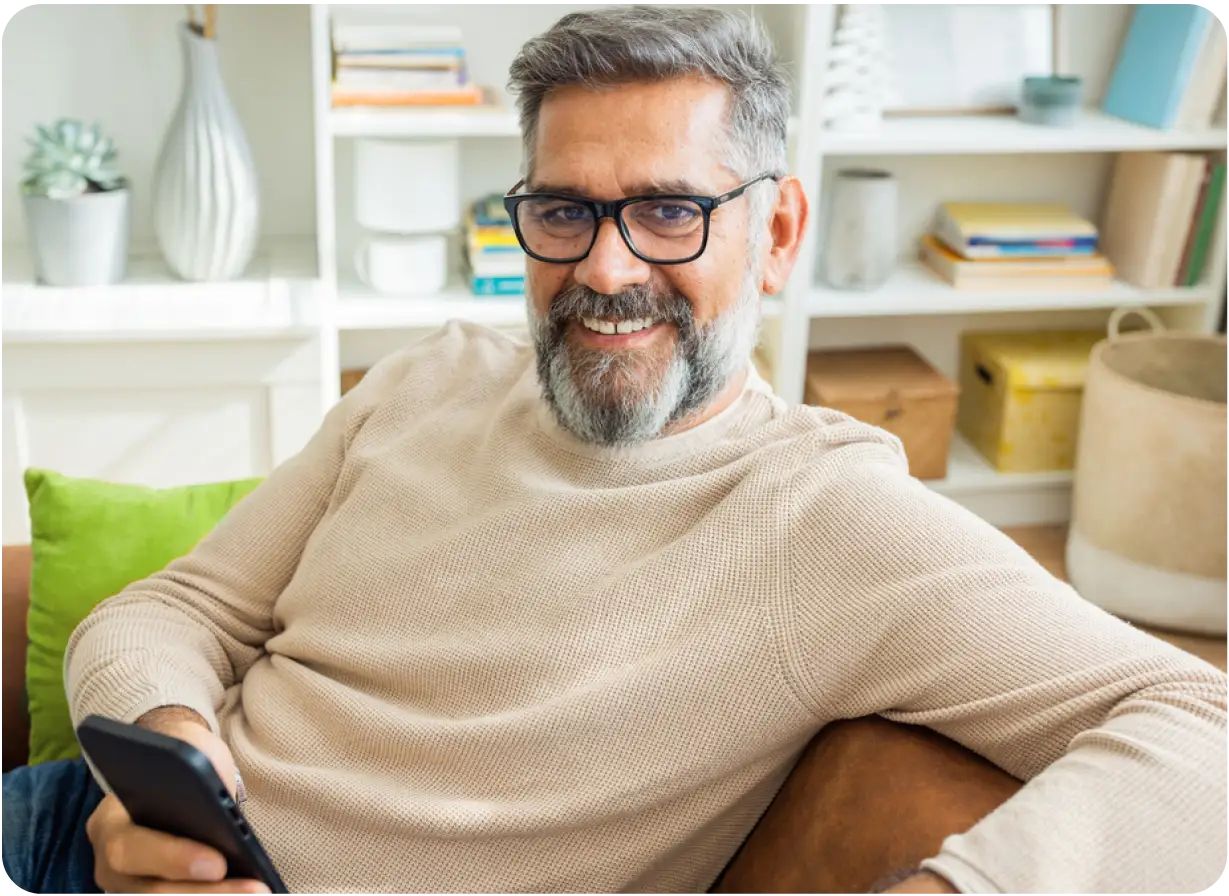 Man Sitting on Couch Holding Phone