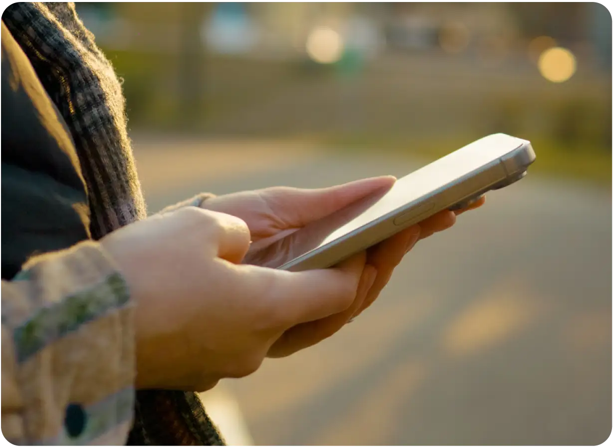 Hands Holding Phone Outdoors