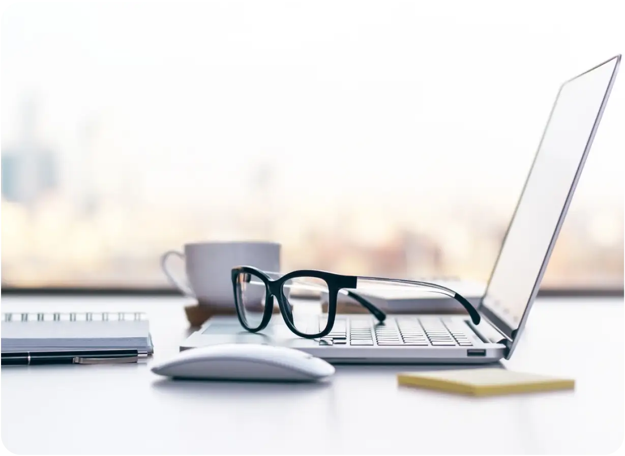 Computer, Reading Glasses, and Coffee Cup on Desk