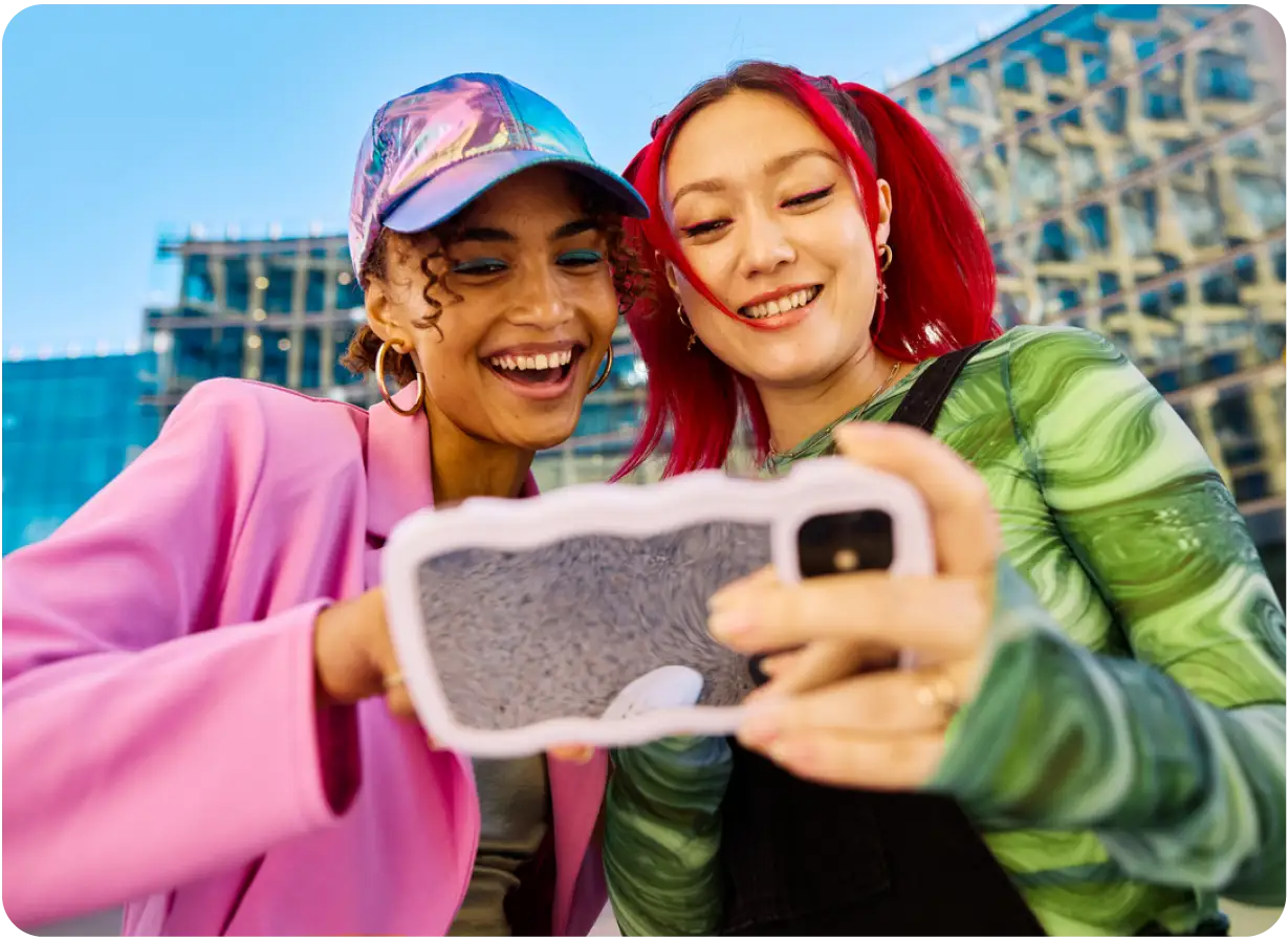 Two Women Happily Looking at Phone Screen