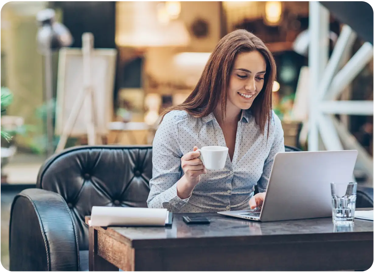 Woman Drinking Coffee Looking at Computer Screen