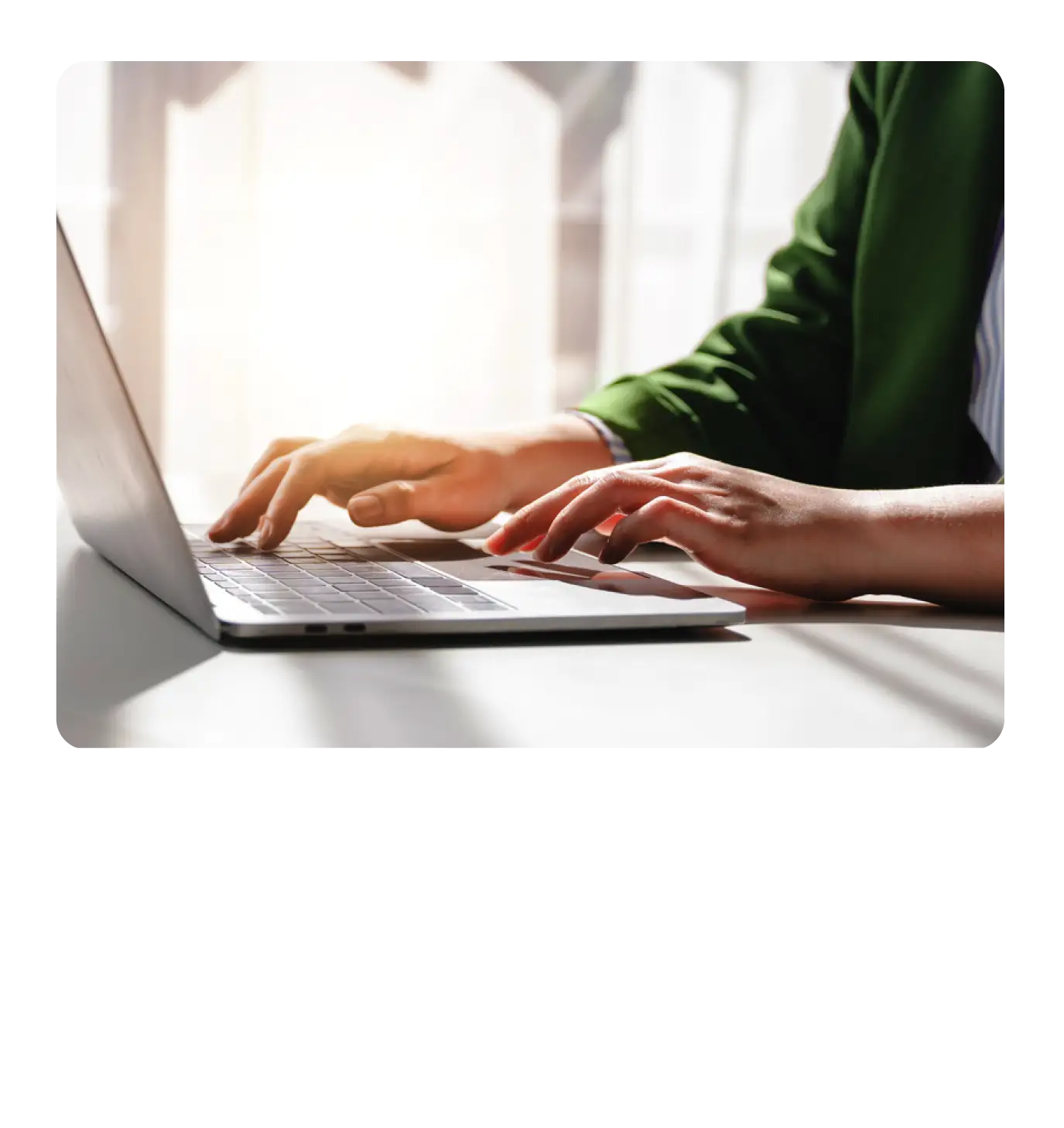A close-up of hands typing on a laptop keyboard
