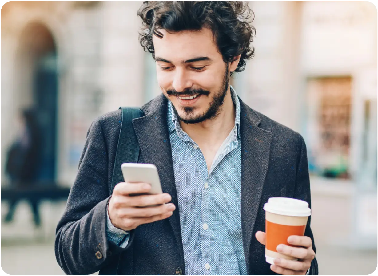 Man Drinking Coffee Looking at Phone