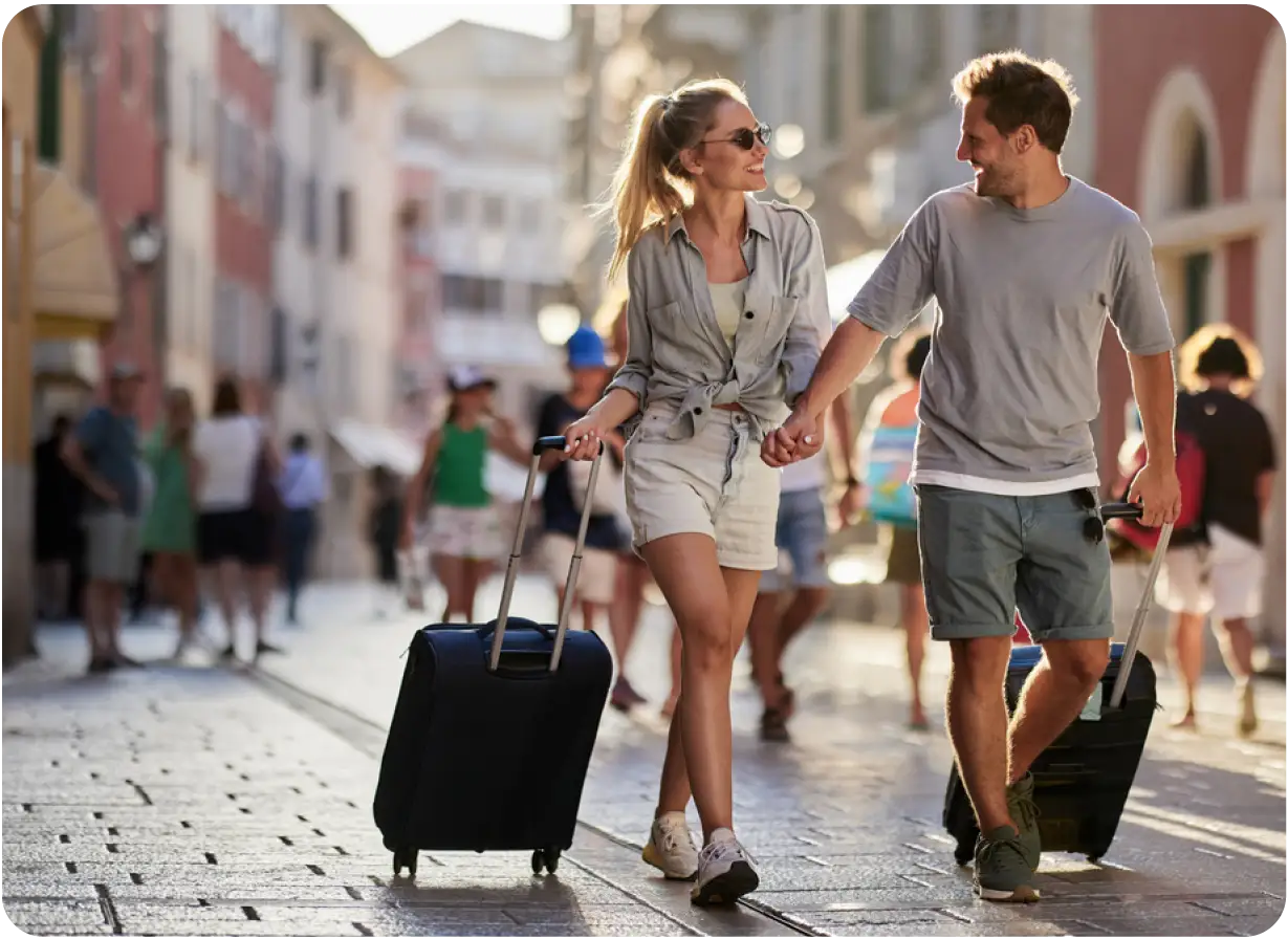 Couple Happily Walking Cobblestone Streets with Luggage