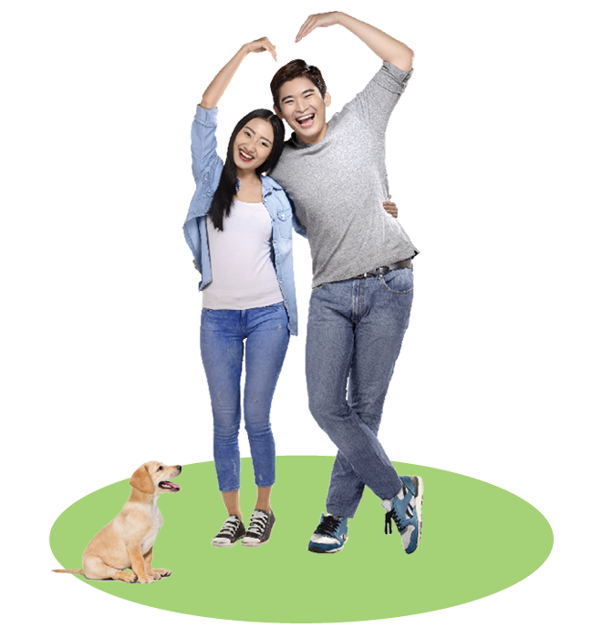A young couple forming a heart with their hands. Their puppy stands beside them.