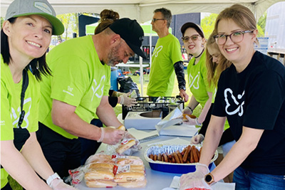 Picnic in the Park volunteers wrapping hot dogs