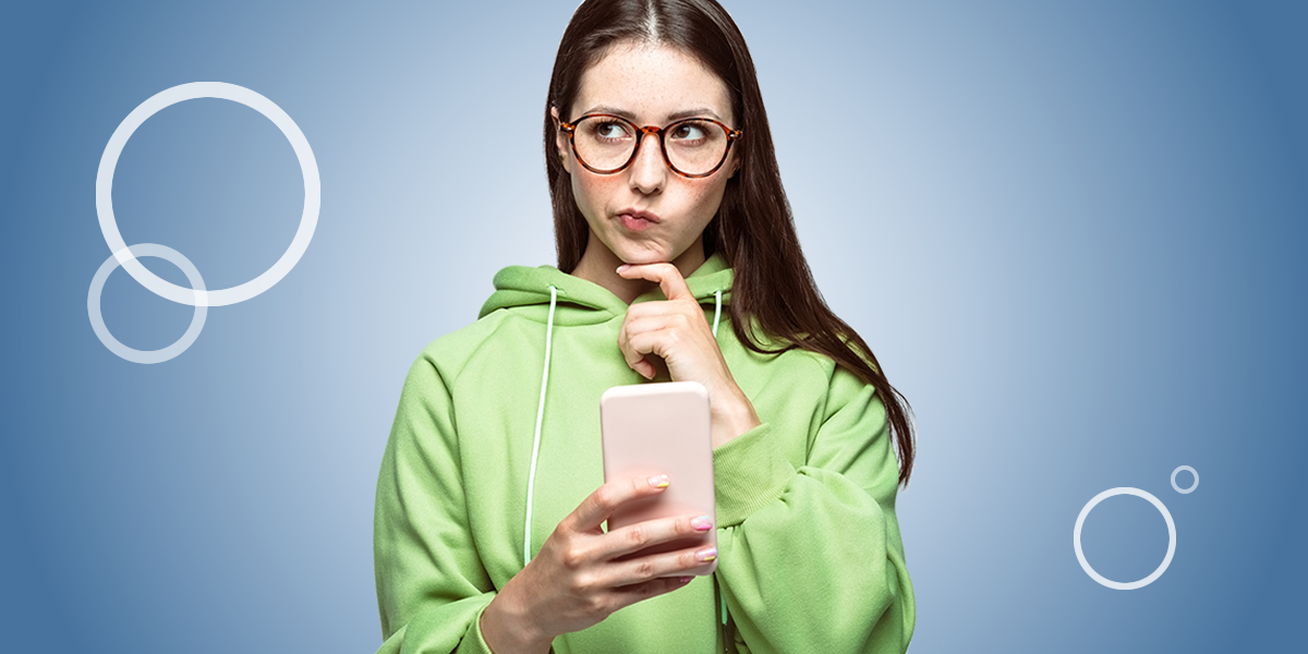 Young woman thinking holding a mobile phone