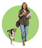 Female student on her phone walking with a dog