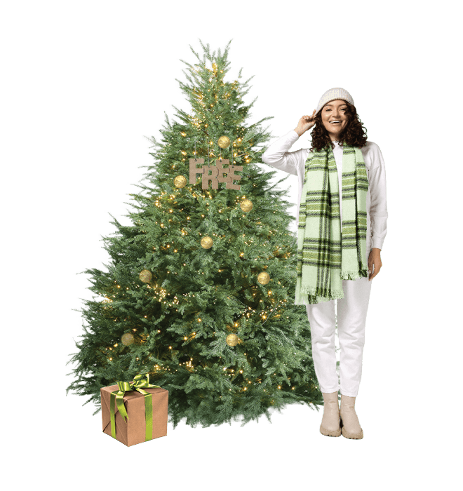 Christmas tree with woman standing beside it. Tree is decorate in Loonies and a FREE ornament.
