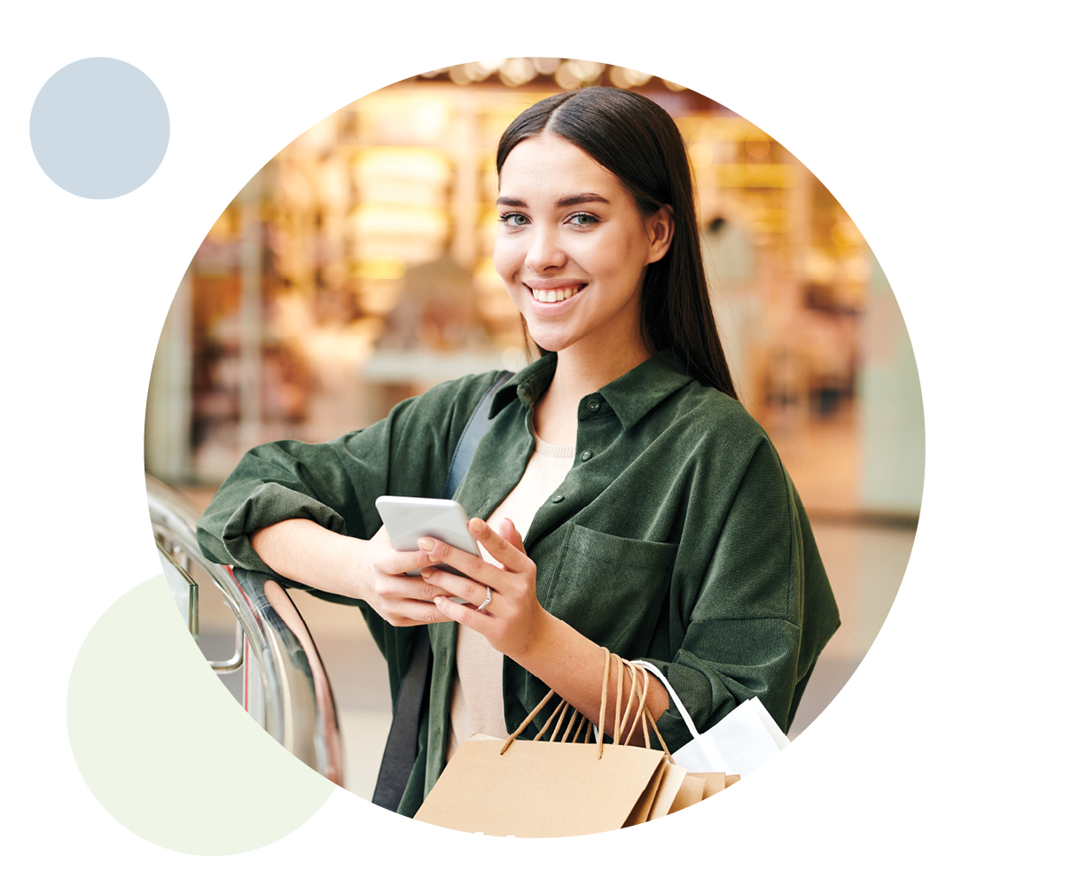 Happy female shopping carrying mobile phone