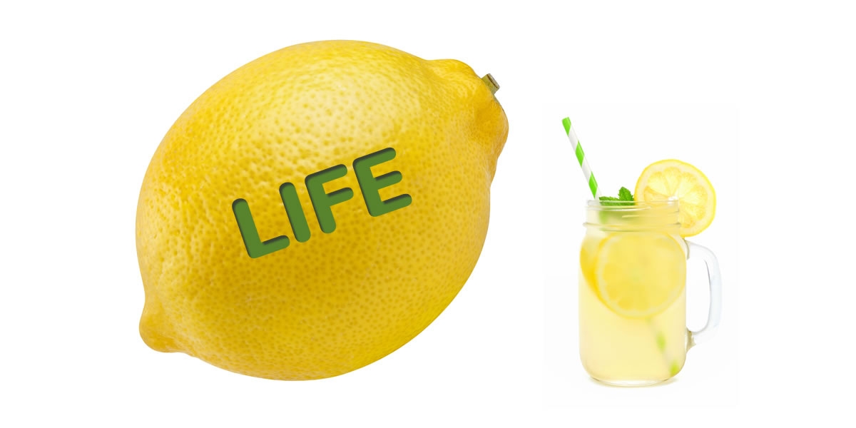 A lemon with the word "life" on it beside a glass of lemonade