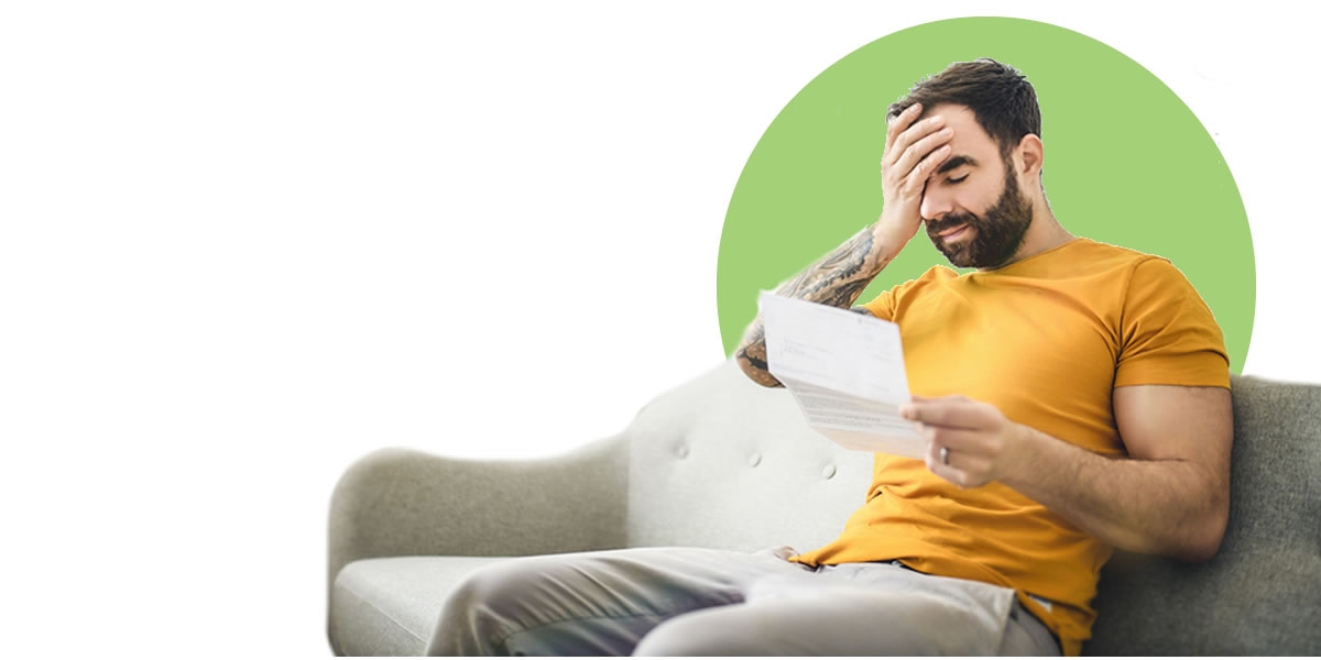 A stressed man looking a credit card statement