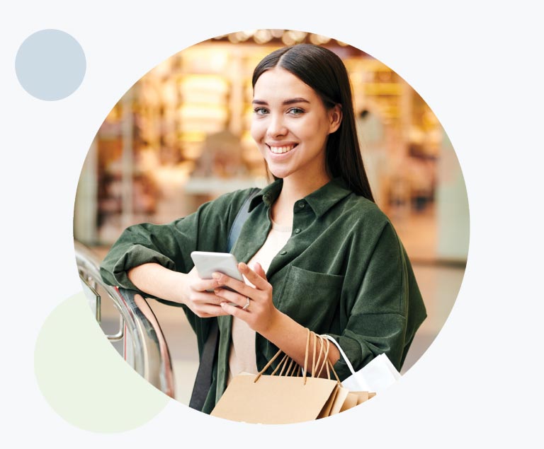 Happy female shopping carrying mobile phone